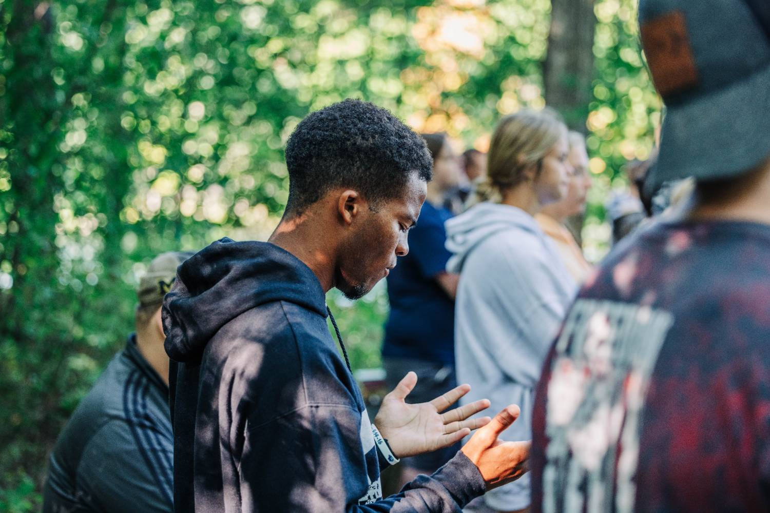 Student in Chapel with raised hands worshiping.