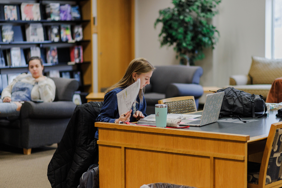 Student working in the library on homework.