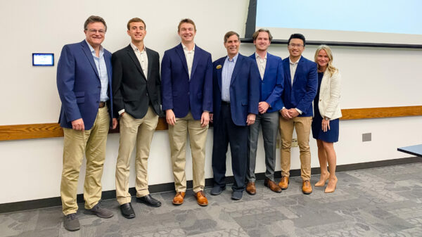 Group of people standing in a row smiling for picture
