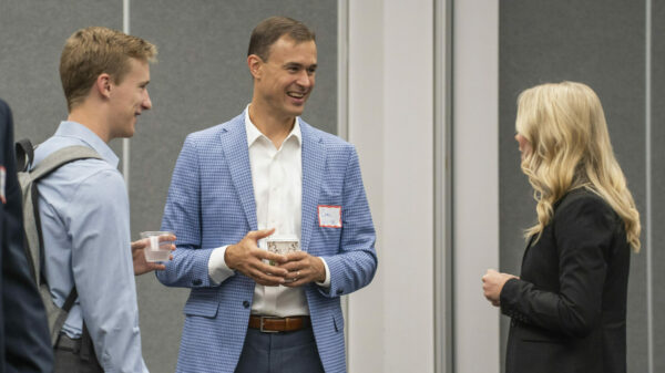 Two men and a woman talking and networking.