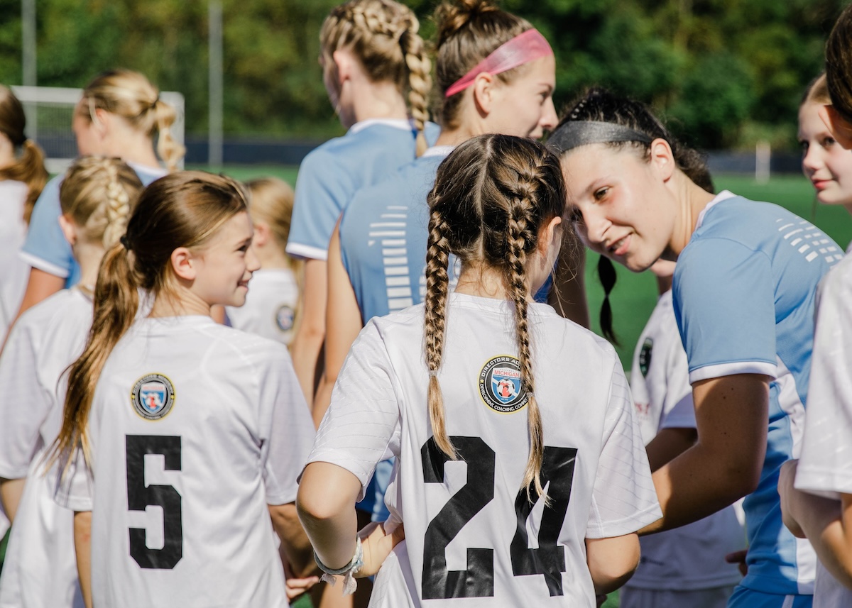 Kids walking out with SAU women's soccer players at a game