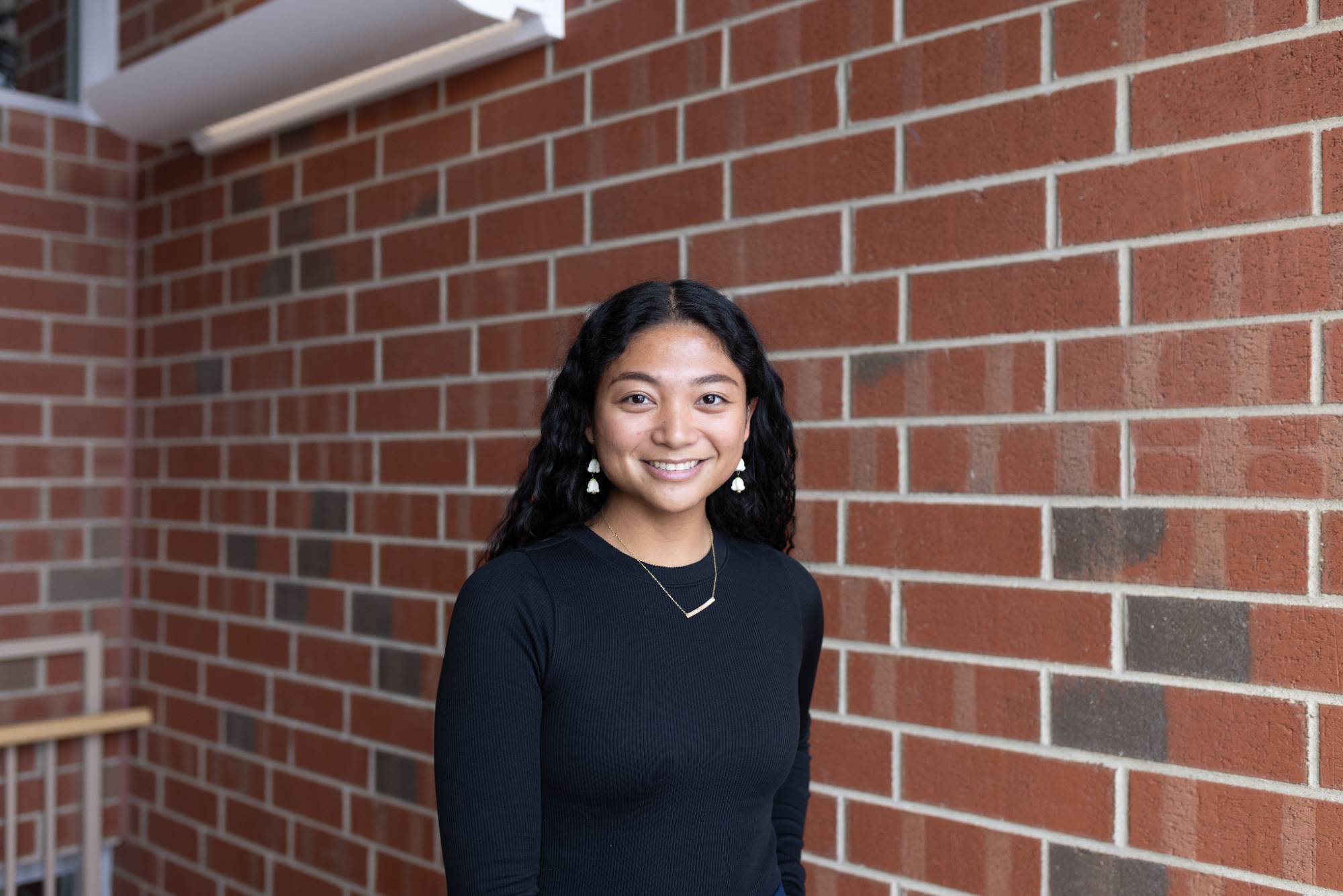 Headshot of the author Mikayla against a brick wall