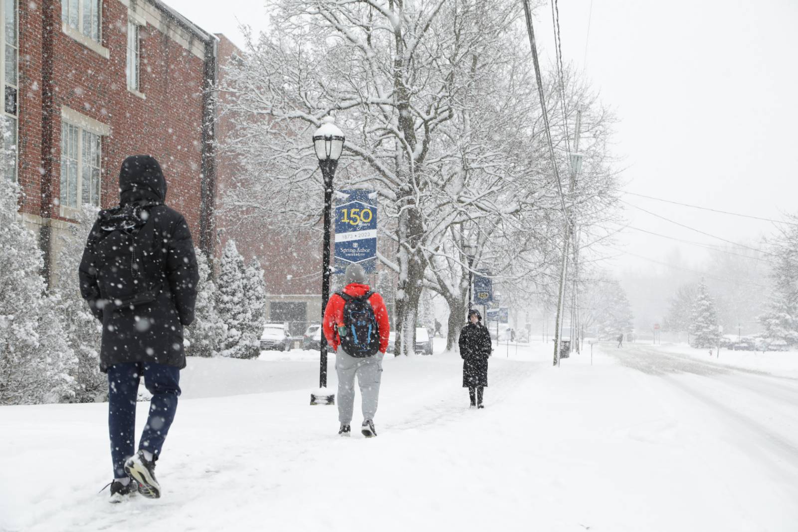 Students walking on a snow-covered sidewalk