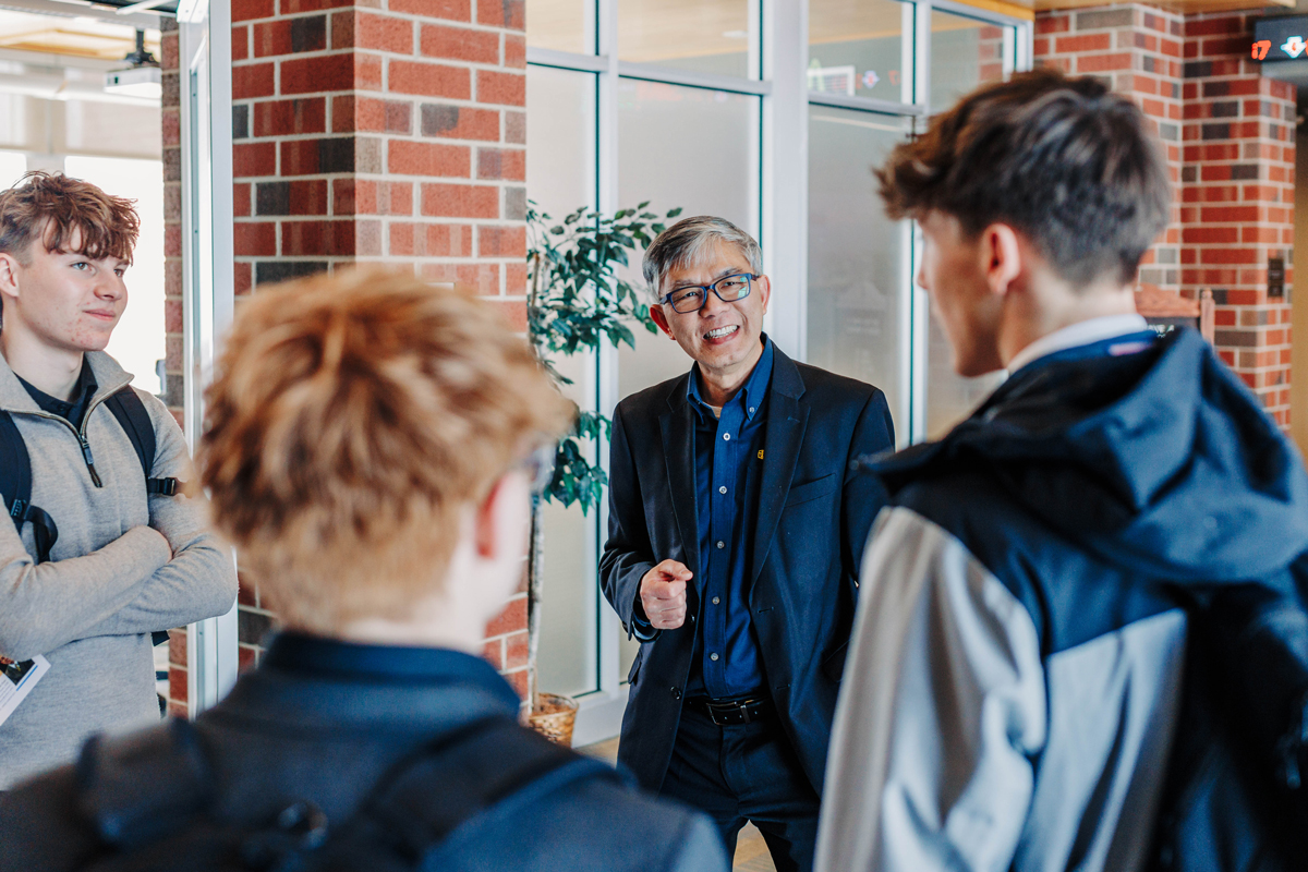 Dr. Chan talking with students in hallway of Poling Center.